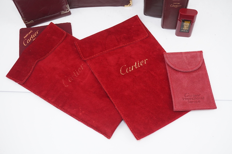 An assortment of Must de Cartier bordeaux leather accessories